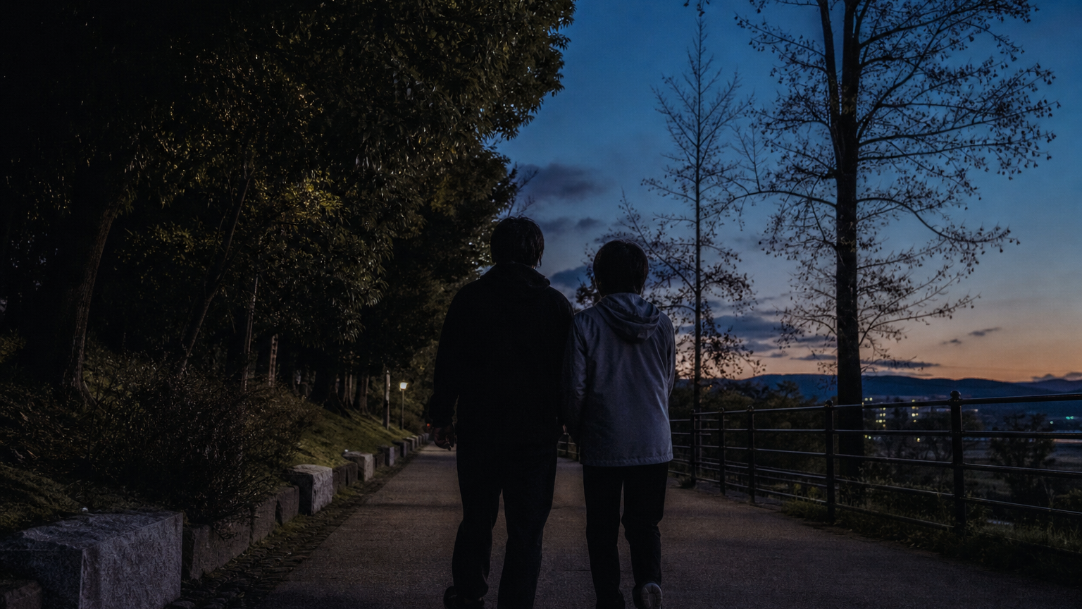 夕暮れの道を並んで歩く二人の後ろ姿